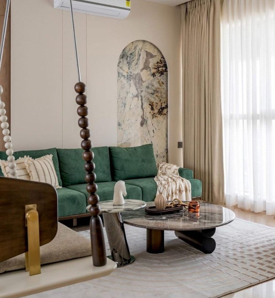 Living room with emerald sofa, marble tables, and a hanging timber swing