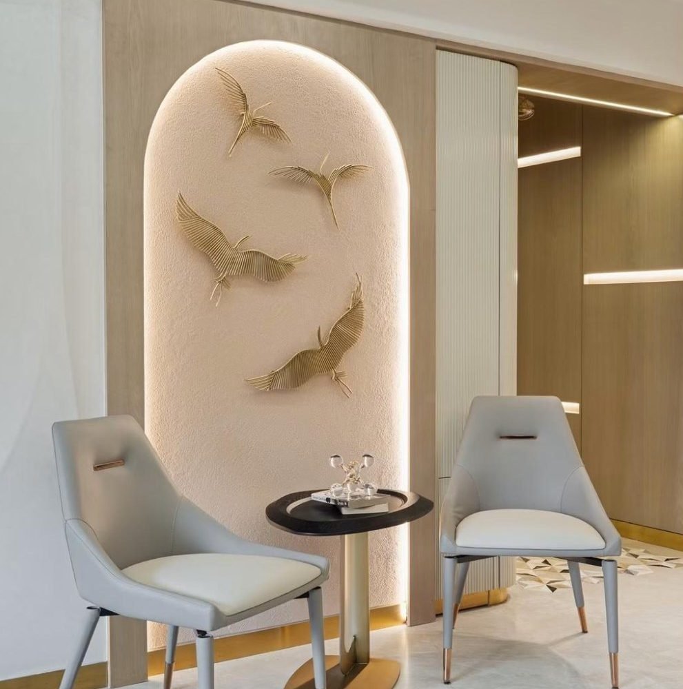 Arched niche with gilded crane relief and pale lounge chairs
