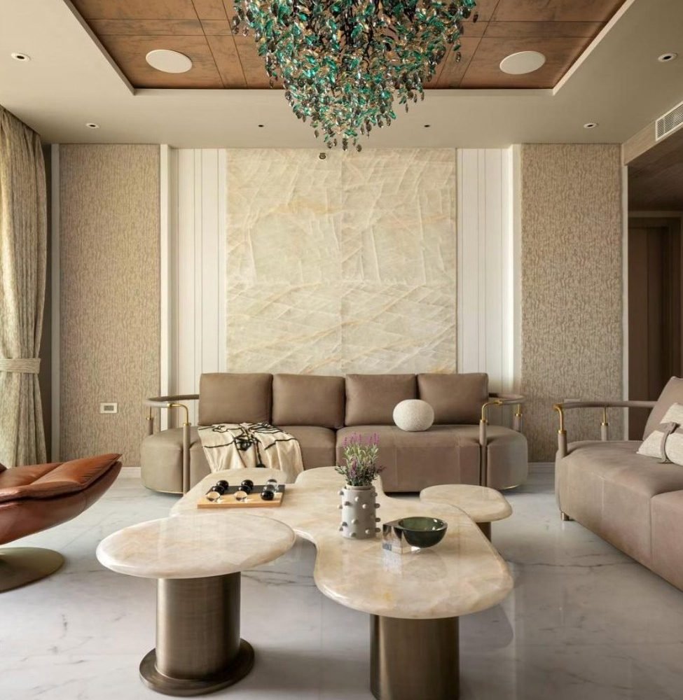 Formal living with organic stone tables and a glass chandelier