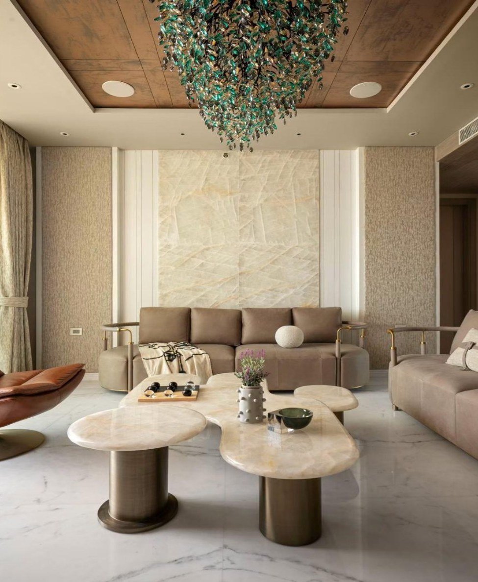 Formal living with organic stone tables and a glass chandelier