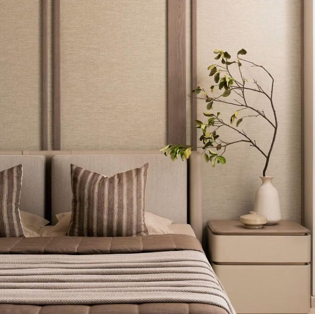 Upholstered twin headboard against fabric-panelled wall
