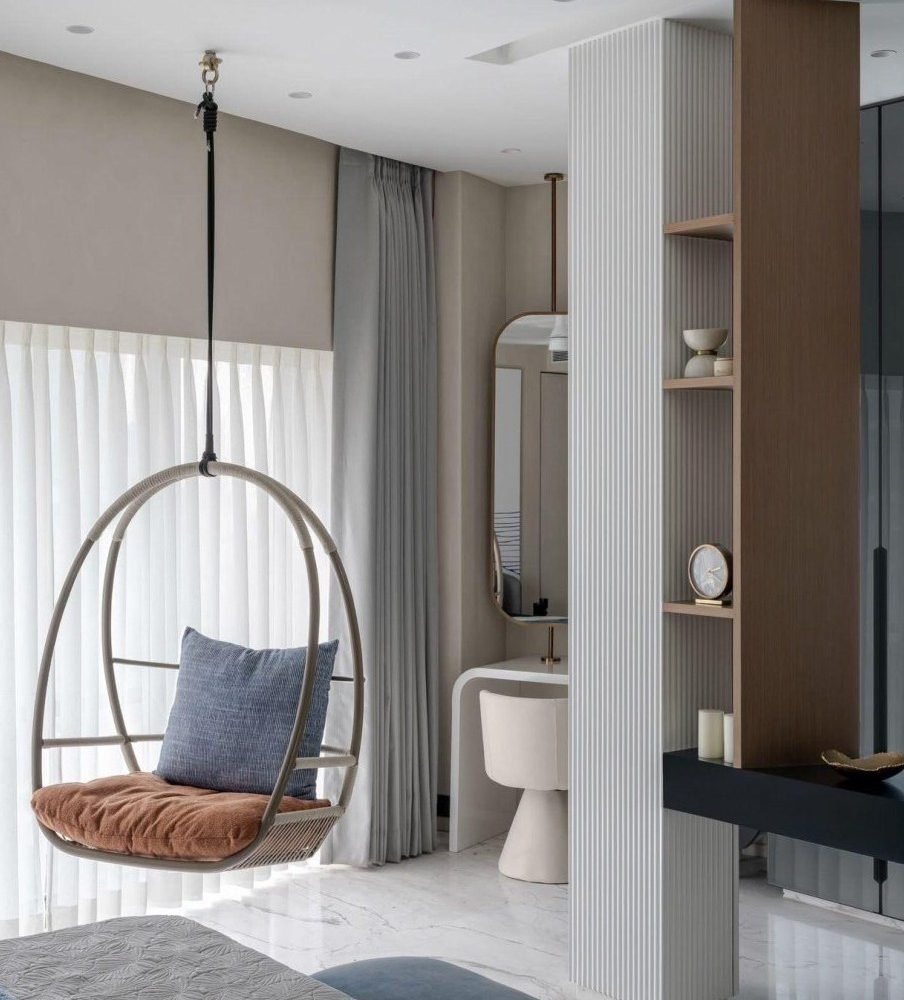 Hanging chair against sheer drapery and a fluted timber screen