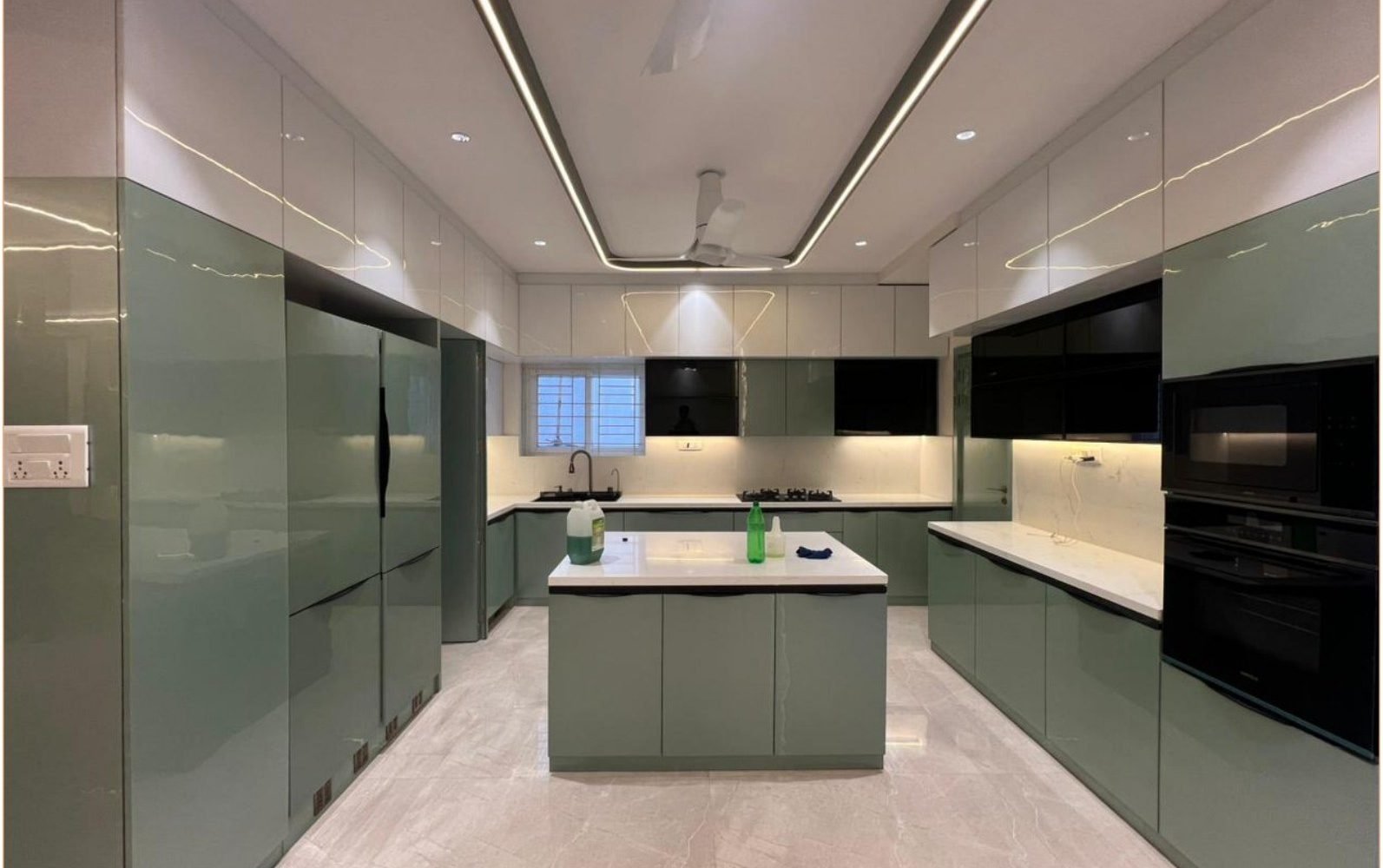 Gloss sage kitchen with island, tall units, and linear ceiling light
