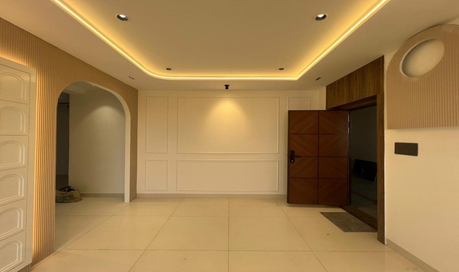 Entrance with coffered lighting, arch, and panelled wall