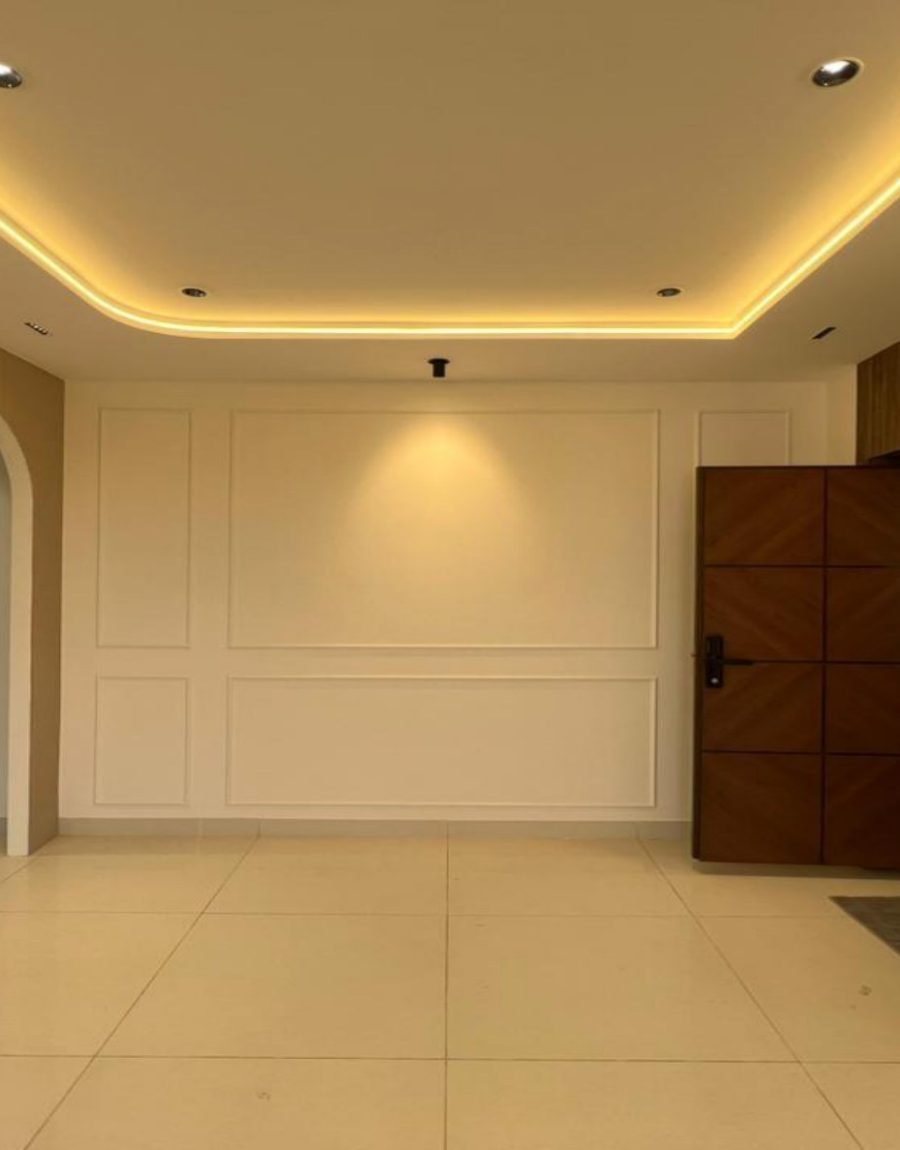 Entrance with coffered lighting, arch, and panelled wall