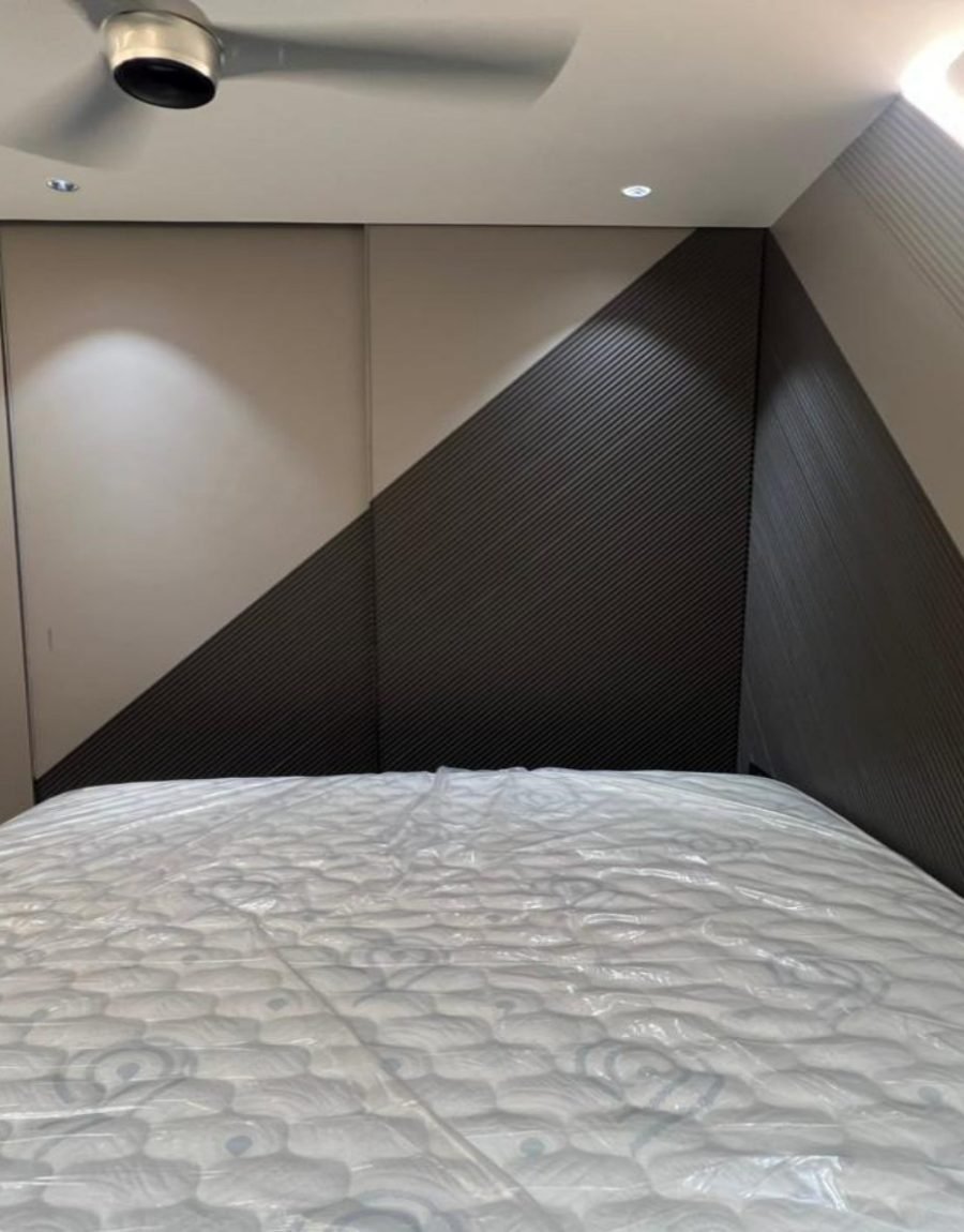 Bedroom with a diagonal fluted headboard wall and a floating platform bed