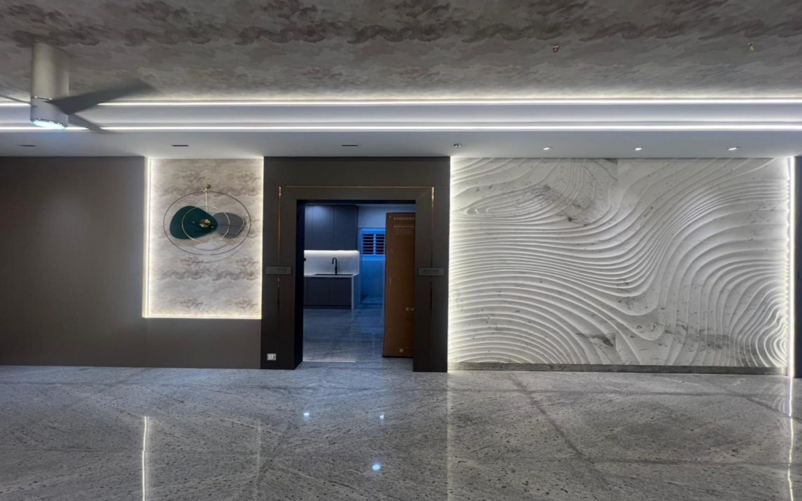 Hall with wave marble, circular metal artwork, and a view to the kitchen