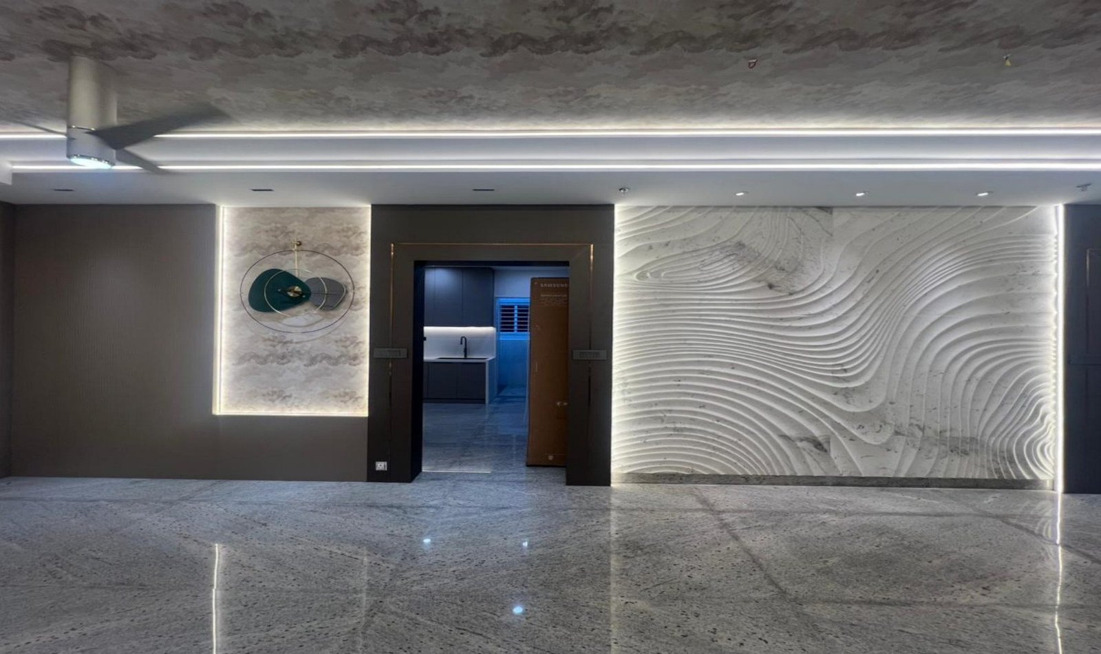 Hall with wave marble, circular metal artwork, and a view to the kitchen