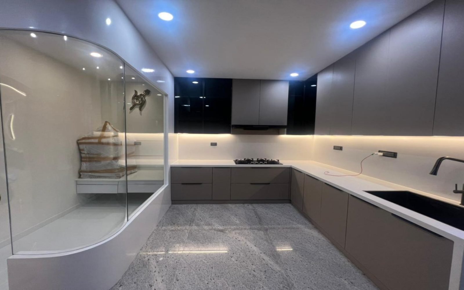 Kitchen with curved glass partition and grey cabinetry