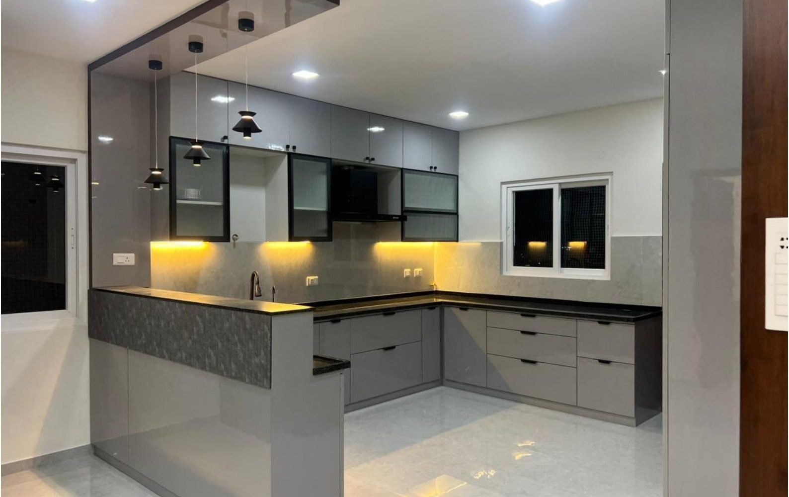 Grey kitchen with breakfast counter and black pendants